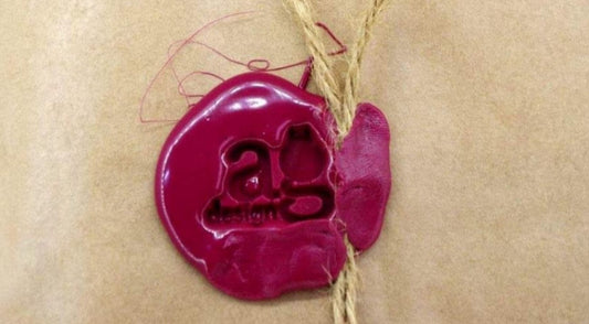 A handmade leather piece wrapped in a natural paper bag, tied with twine and closed with a red wax seal - AG Design, Arad, Romania