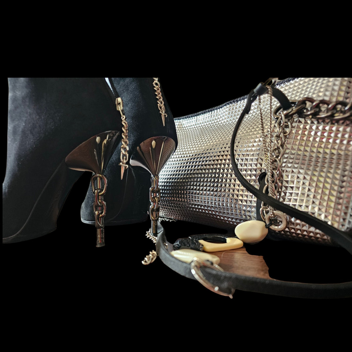 Silver geometric leather crossbody bag with black and cream stones beside black heeled boots on a black background - AG Design, Arad, Romania