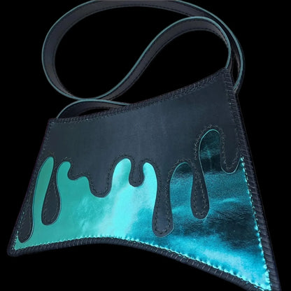 Handmade turquoise leather shoulder bag with a hand-cut asymmetric form revealing a metallic turquoise interior - AG Design, Arad, Romania
