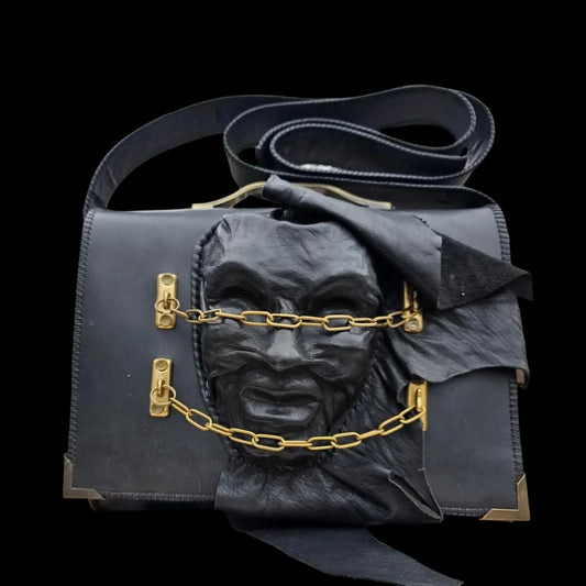 Handmade dark leather bag with a painted mask-like face and gold detail - AG Design, Arad, Romania