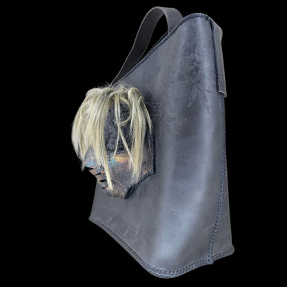 Handmade black leather shoulder bag with an attached 3D sculptural leather mask with metallic and hair-like textures - AG Design, Arad, Romania