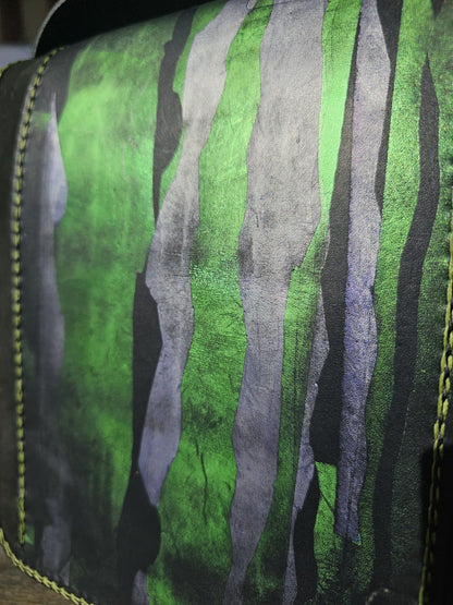 Close-up of the green and grey-navy painting on the black leather flap of a handmade shoulder bag - AG Design, Arad, Romania