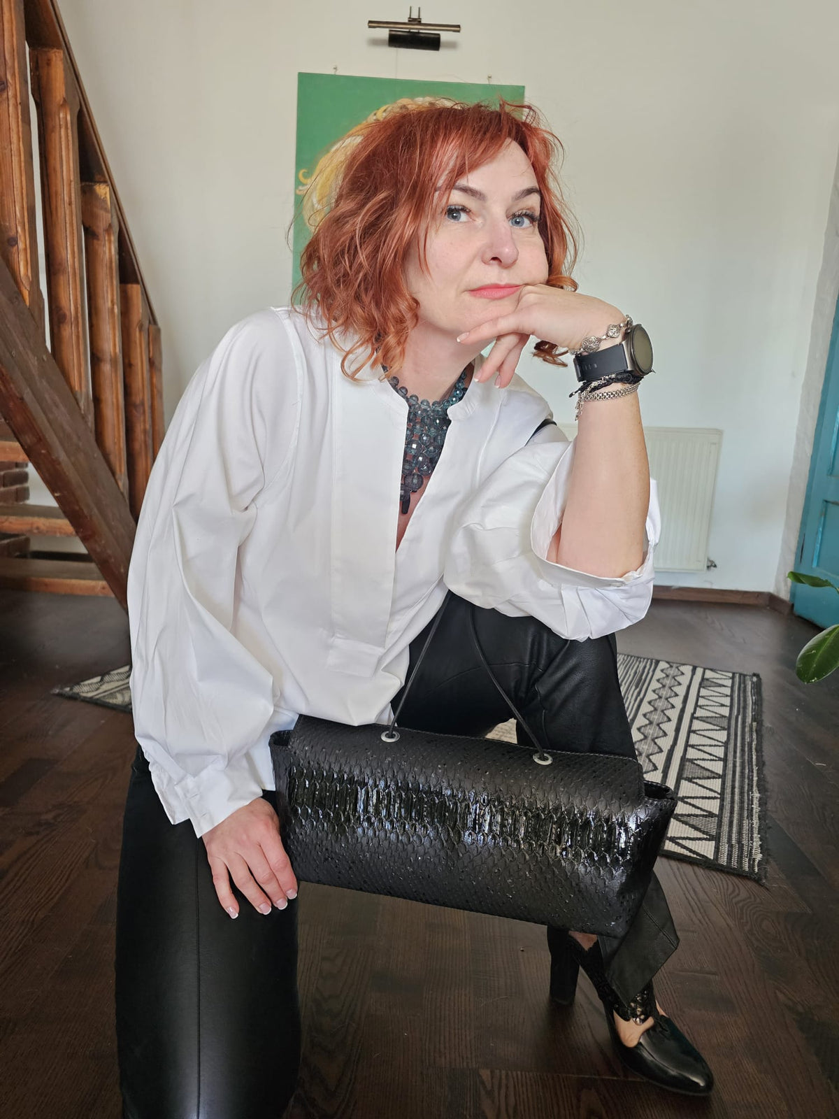 Alexandra holding the long black snake-embossed leather shoulder bag by its slender straps - AG Design, Arad, Romania