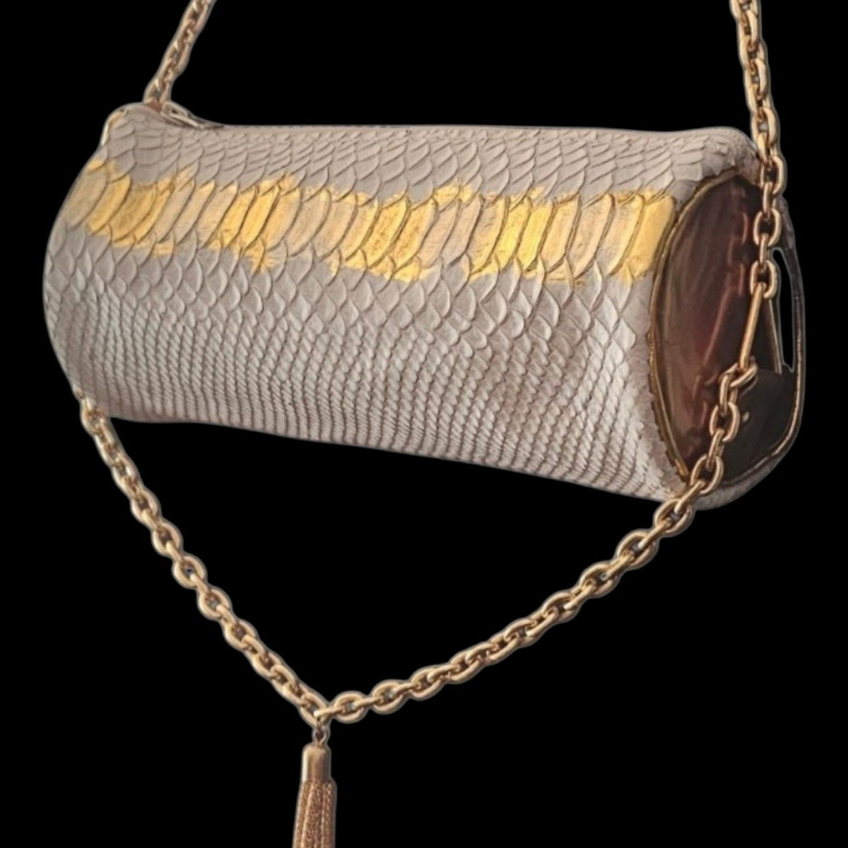 Side view of the white leather barrel bag with metallic gold leather ends, gold-tone chain and long tassel on a black background - AG Design, Arad, Romania