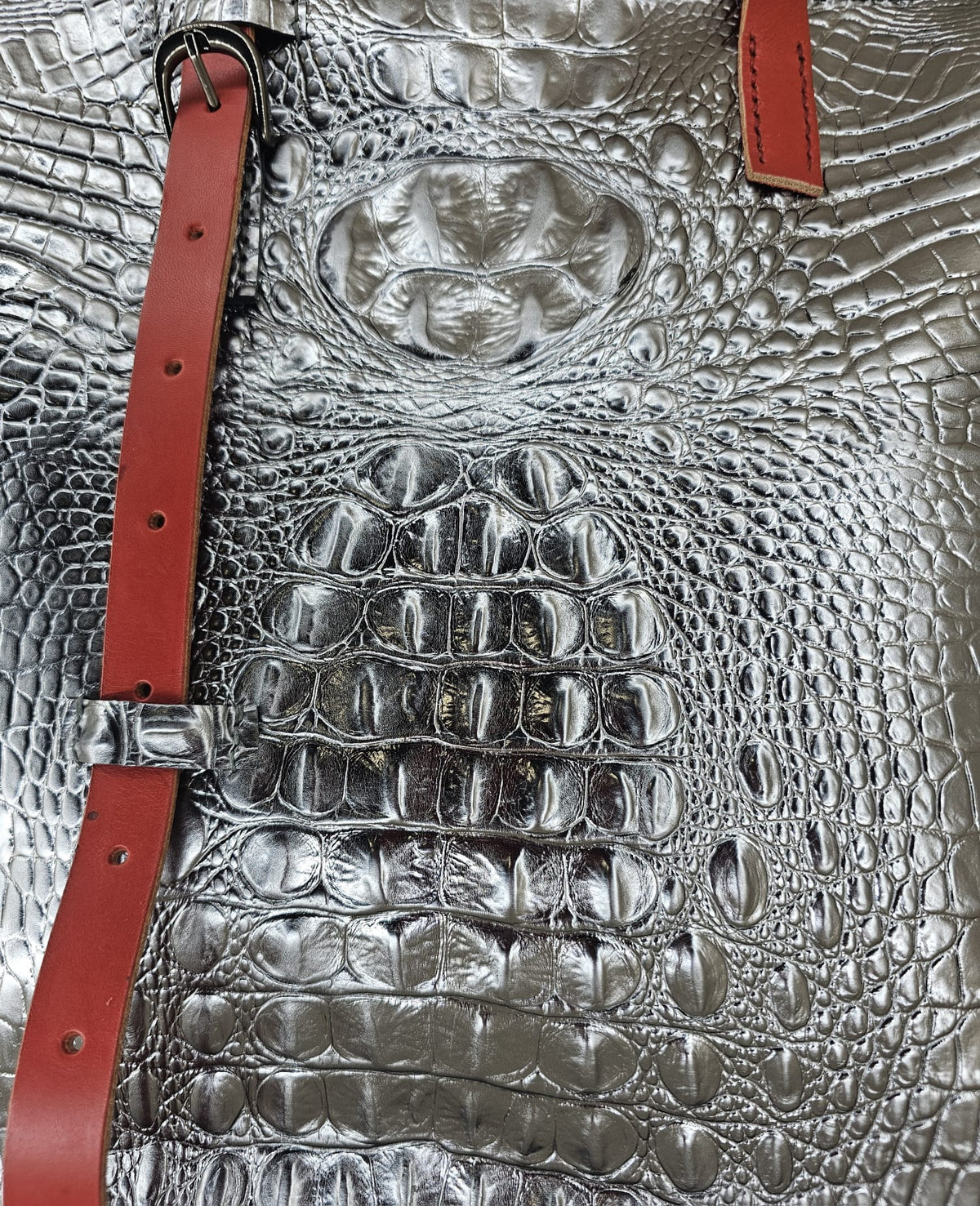 Close-up of the crocodile-embossed leather texture on a handmade silver shoulder bag - AG Design, Arad, Romania.