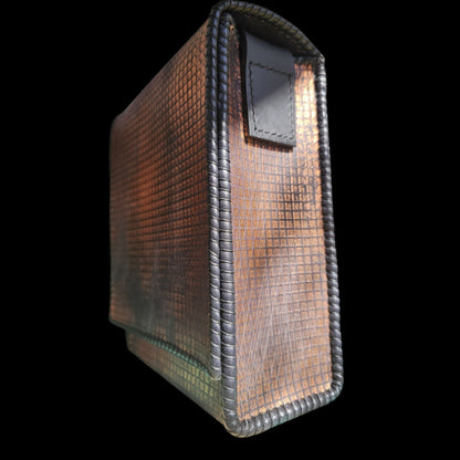 Side profile of a handmade grey leather crossbody bag with a hand-stamped copper pattern - AG Design, Arad, Romania.