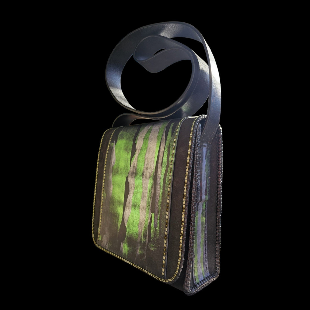 Three-quarter view of a hand-painted black leather shoulder bag with green strokes and a looped leather strap - AG Design, Arad, Romania