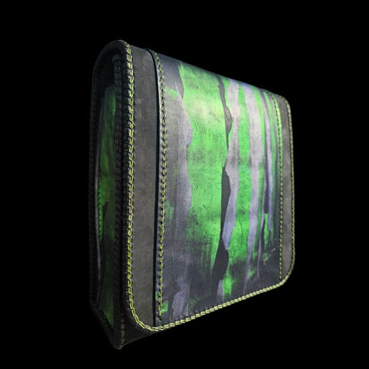 Side view of a hand-painted green and black leather shoulder bag showing the laced edge and green stitching - AG Design, Arad, Romania
