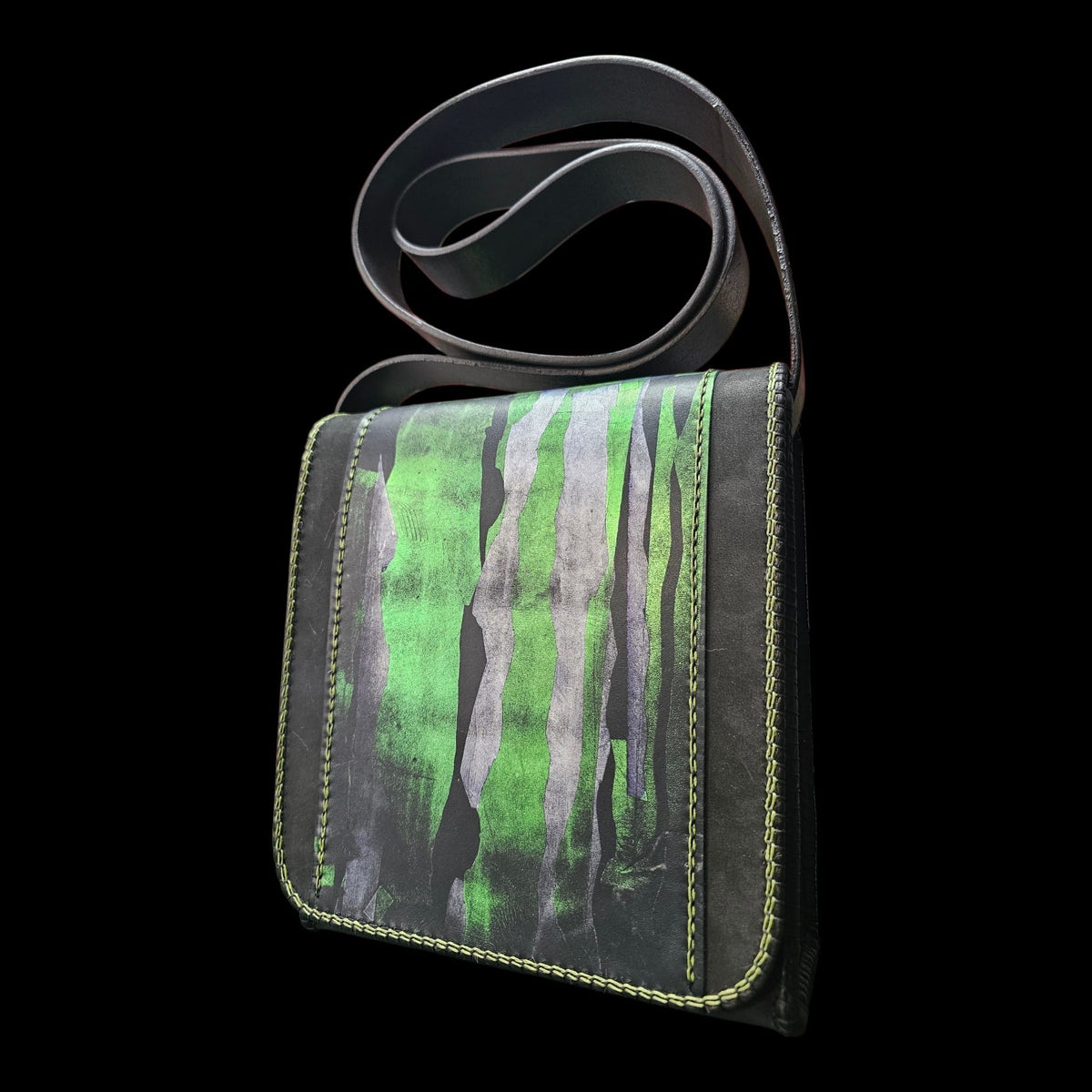 Handmade black leather shoulder bag hand-painted in green and grey, seen at a slight angle with its strap above - AG Design, Arad, Romania