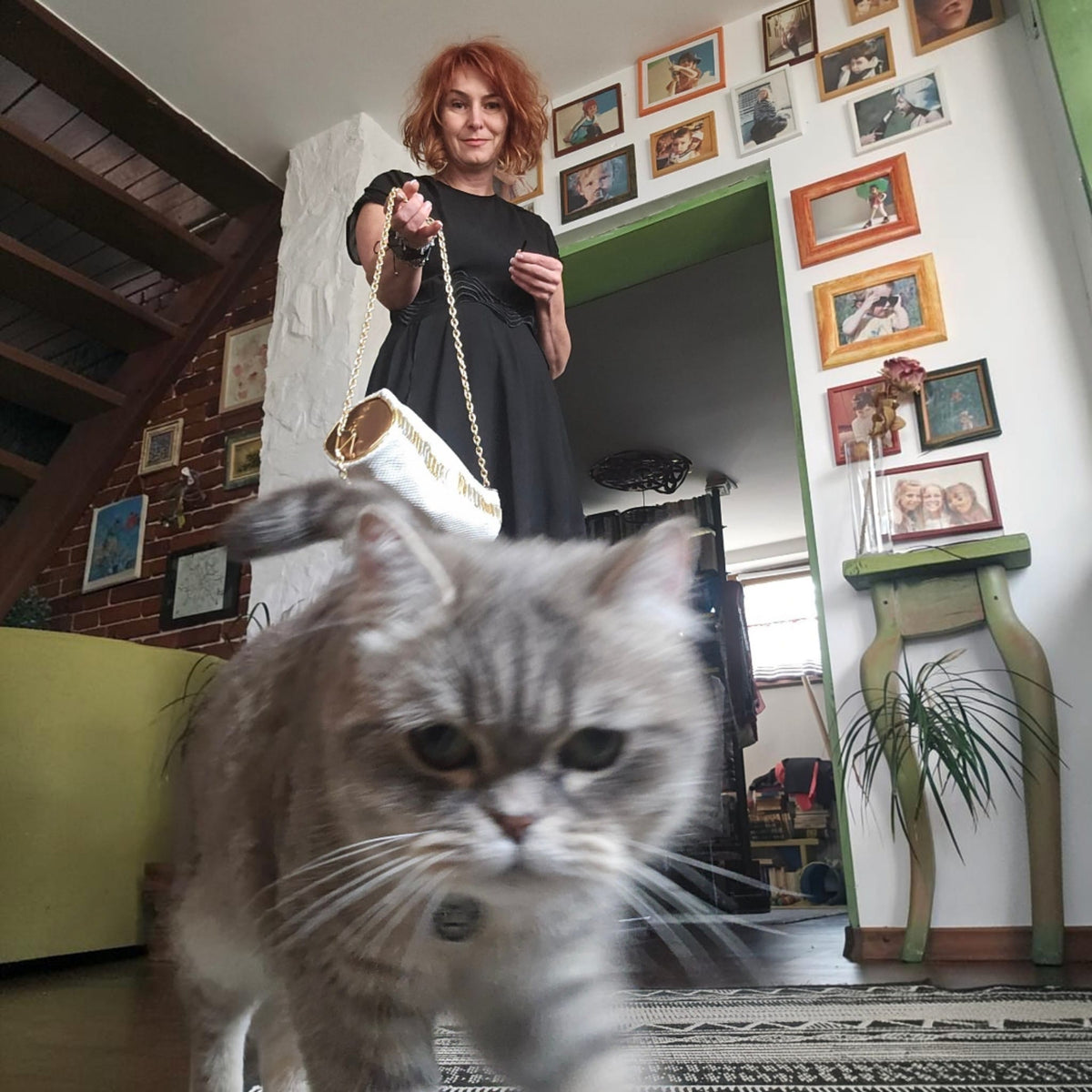 Alexandra holding the white and gold leather barrel bag while a grey cat walks toward the camera - AG Design, Arad, Romania