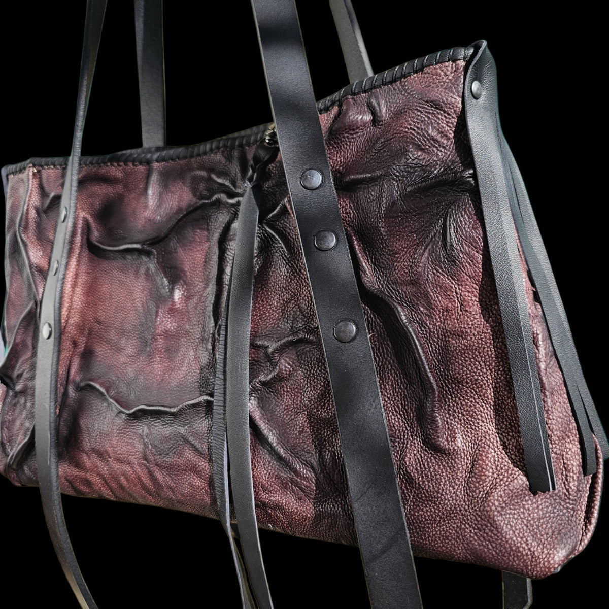 Another angle of a handmade relief leather shoulder bag, showing its folded surface and riveted straps - AG Design, Arad, Romania