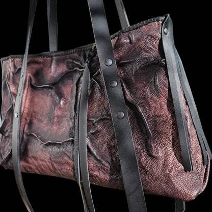 Another angle of a handmade relief leather shoulder bag, showing its folded surface and riveted straps - AG Design, Arad, Romania