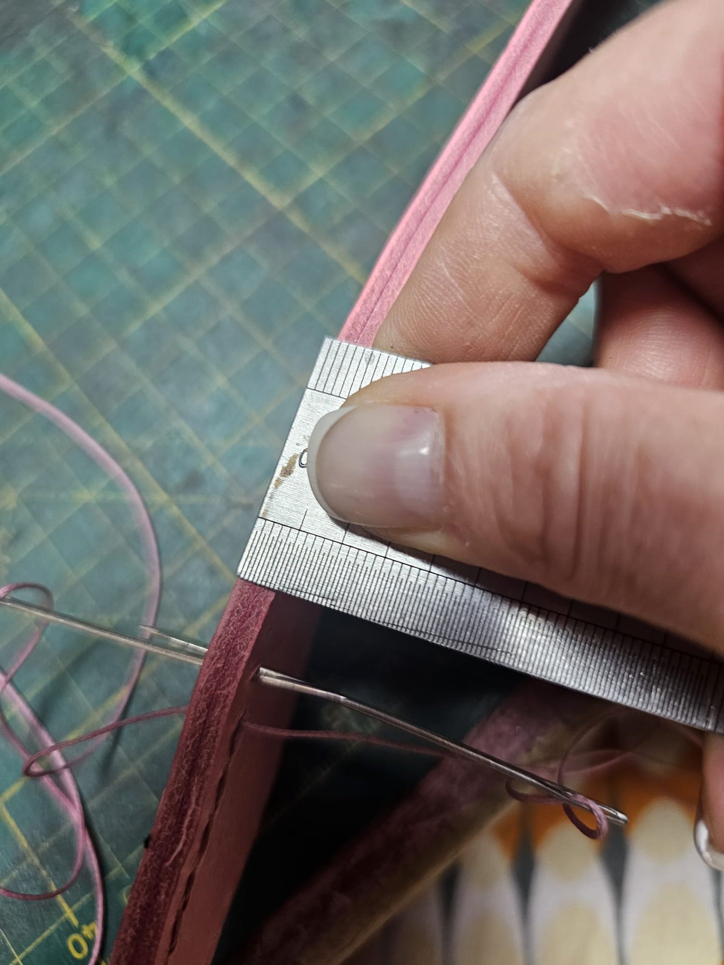 Hand-stitching the five millimetre thick leather of a handmade pink belt pouch with two needles - AG Design, Arad, Romania