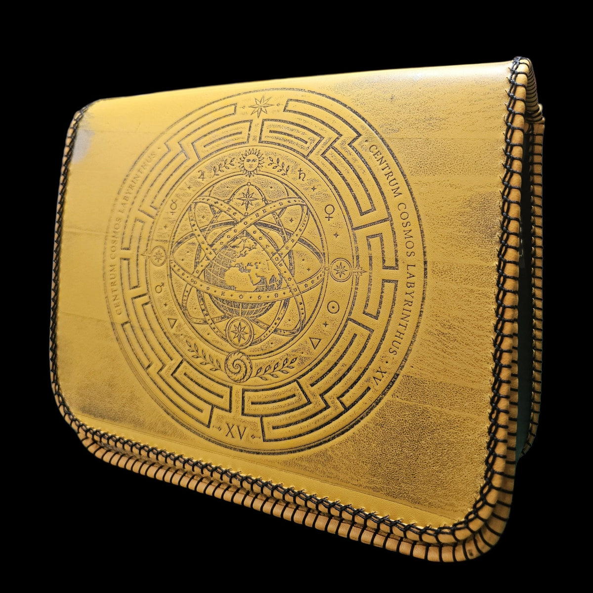 Handmade mustard yellow leather crossbody bag turned slightly to the left, showing the tooled sphere in raking light - AG Design, Arad, Romania