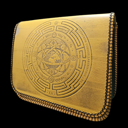 Handmade mustard yellow leather crossbody bag turned slightly to the left, showing the tooled sphere in raking light - AG Design, Arad, Romania