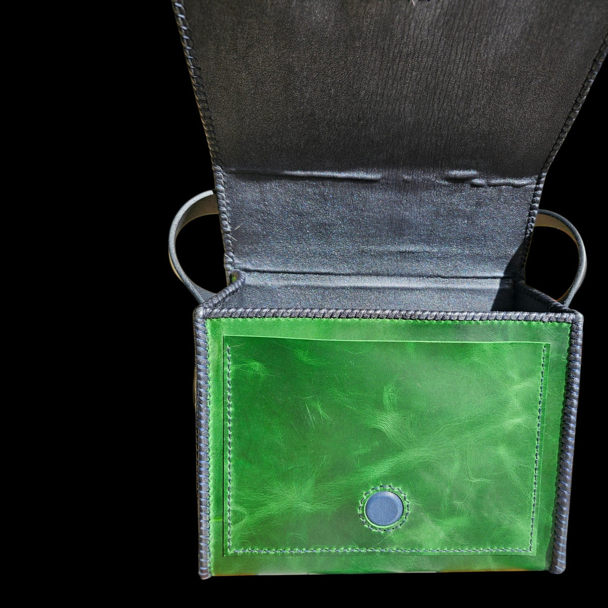 Open handmade green leather crossbody bag showing the lambskin lining and inner pockets - AG Design, Arad, Romania