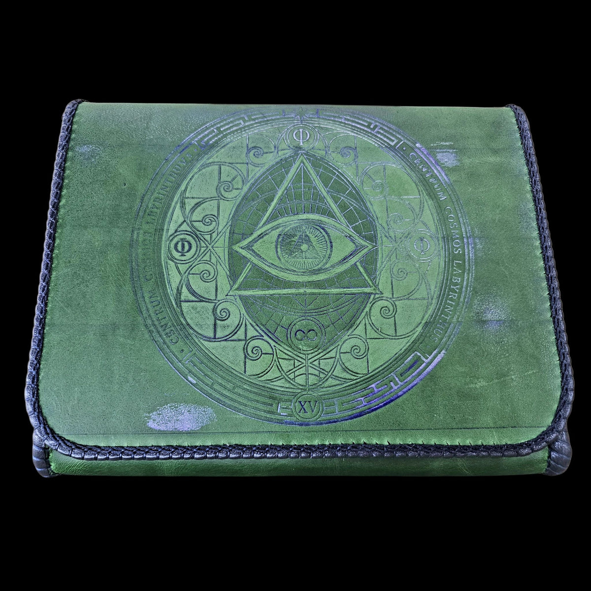 Front flap of a handmade green leather crossbody bag embossed in blue with an eye, the letter Phi and a Latin inscription - AG Design, Arad, Romania